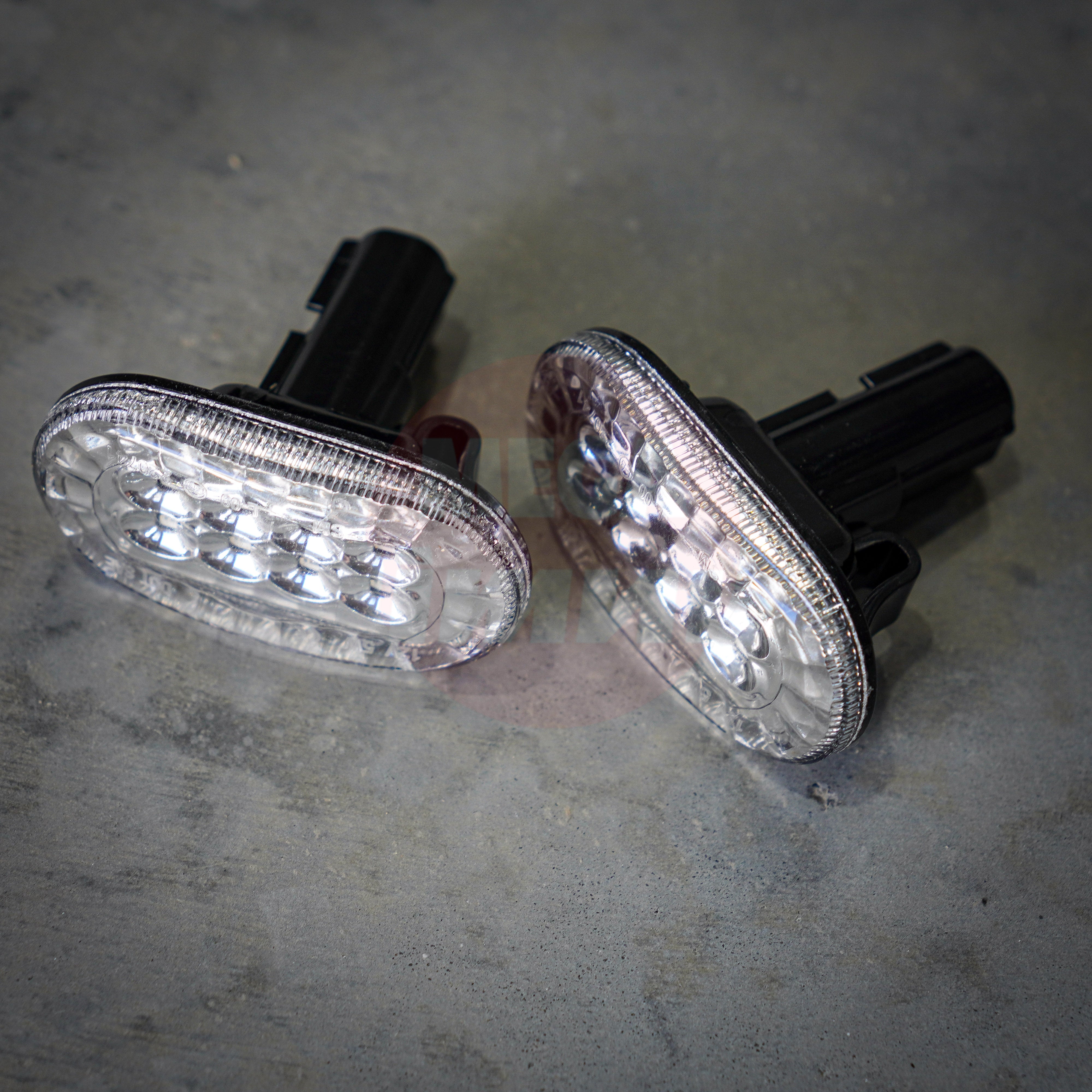 Two LED Jimny indicators on a concrete surface